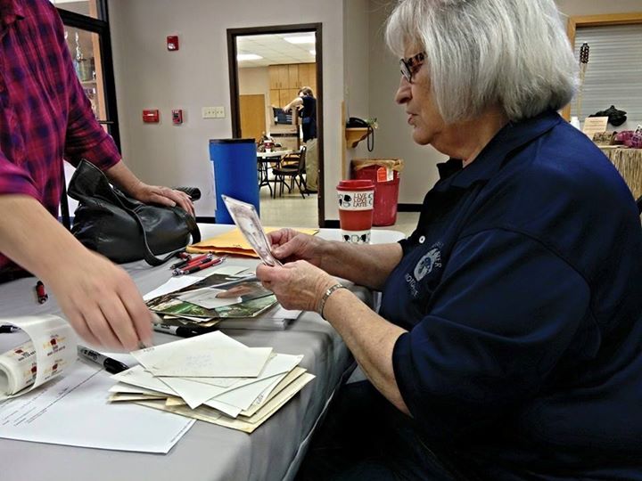 Carthage Save Your Photos Day volunteer and board member Carol prepares images for scanning